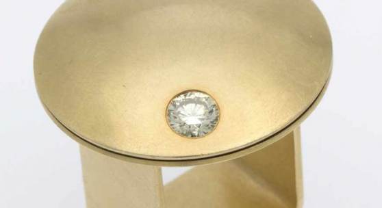 Kinetischer Brillant-Ring "Sternschnuppe" von Barbara Schulte-Hengesbach Gelbgold 750, gebürstet. Runder pilzförmiger Ringkopf, ausgefasst mit 1 Brill. ca. 0,55 ct, Getönt/VS-SI. Firmensignet: S-H. RG 52. Ca. 30,9 g. Aufrufpreis:	1.300 EUR