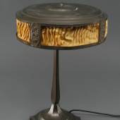 KatalogNr: 1478 Tischlampe, Metall/Blech, bronziert, runder Schirm mit plissierten Seiden-Einsätzen, leicht brüchig, reliefiertes Rosenrelief, um 1920, elektrifiziert, starke Altersspuren