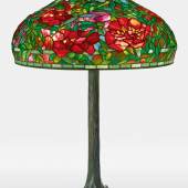 Lot 311 Tiffany Studios "Elaborate Peony” Table Lamp with a "Tree" base shade impressed TIFFANY STUDIOS NEW YORK 1903 base impressed TIFFANY STUDIOS/NEW YORK/553 leaded glass and patinated bronze 33 in. (83.8 cm) high 22 1/4  in. (56.5 cm) diameter of shade circa 1910 Estimate $350/500,000