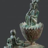 In diesem rundplastischen Bronzewerk ist das Bildmotiv des Sonnenkindes auf der Lotusblüte zu erkennen und somit die ikonographische Umsetzung der Vorstellung, dass die Sonne täglich neu geboren wird und sich verjüngt. Spätzeit, 6.–4. Jh. v. Chr.