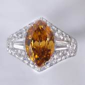 Bulgari Fancy Intense Yellowish Orange Natural Colour Diamantring 2,79 ct, Platin 950, Diamant im Navetteschliff, zwei Diamanten im Trapezschliff und Brillanten, zus. ca. 2,20 ct Schätzwert € 70.000 - 100.000