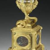 Paris, 18. Jahrhundert. Auf Werk bez. Courieult A Paris
Elegantes fein ziseliertes, feuervergoldetes Bronzegehäuse in Vasenform auf quadratischem Marmorsockel. Im Vasenaufsatz zwei sich drehende Ziffernringe, feststehender Zeiger sowie eine sich um die Uhr windende Schlange. Ziffernringe mit weißen Emailkartuschen, römischen Ziffern und arabischer Minuterie. Großes Messingwerk mit 8-Tagen-Laufdauer, Halbstundenschlag auf Glocke und Fadenaufhängung des Pendels. H. 48 cm (6211048)

Eine vergleichbare Uhr, allerdings ohne Marmorsockel, ist bei P. Kjellberg, La Pendule Francaise, S. 285, Abb. D. dargestellt.