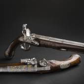 Paar prunkvoller Steinschlosspistolen um 1780. Unter der Losnummer 8114 kamen die eisengeschnittenen Pistolen mit reichen Darstellungen antiker Krieger auf vergoldetem Grund für 5.000 € 