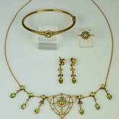 PARÜRE fünfteilig, Jugendstil: Collier, Ring in Blütenform, Paar Ohrgehänge, Armreif, jeweils besetzt mit Orientperlen und geschliffenen Peridotsteinen in Goldfassung. Mindestpreis:	850 EUR