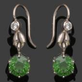 Paar Demantoid-Ohrringe A pair of demantoid earrings Wohl Fabergé, um 1920. 750er WG, Aufrufpreis:	1.250 EUR Schätzpreis:	1.600 EUR Zuschlagspreis:	2.800 EUR