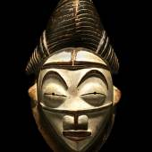 Punu-Maske Höhe: 31 cm. Aus Holz. Gabun. Die weißen Okuyi-Masken verkörpern den Geist eines angesehenen Ahnen und traten meist in den frühen Morgenstunden oder in der Abenddämmerung und hauptsächlich an Beerdigungen auf. Schätzpreis:	30.000 - 50.000 EUR