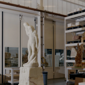 The large fabrication hall in Barry X Ball’s studio. On the left, Ball’s Pietà (2011–22), sculpted from translucent white Iranian onyx (after the Pietà Rondanini (1552–64) by Michelangelo Buonarroti). To the right, the “arabescato” Saint Bartholomew Flayed – Ascension (2011–21), created from French Rouge du Roi marble (after San Bartolomeo Scorticato (1562) by Marco d’Agrate). Photo: Vincent Tullo.