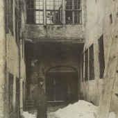 Vilhelm Hammershøi in the courtyard outside Strandgade 30, with his wife Ida at the window 
